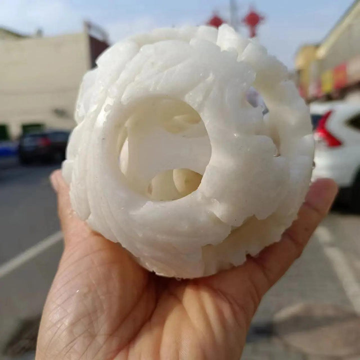 Hand-carved natural white jade ball with intricate openwork, perfect for Reiki healing, energy, and spiritual divination.