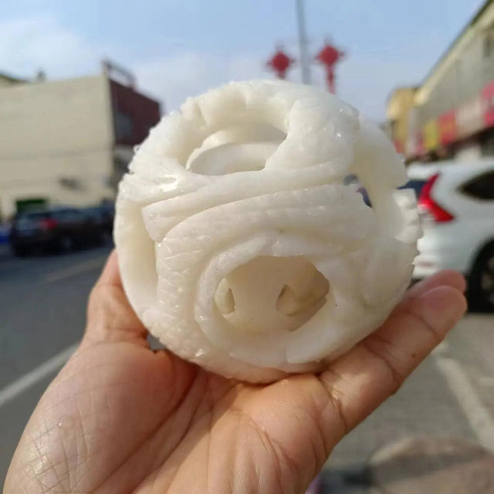 Hand-carved natural white jade ball with intricate openwork, perfect for Reiki healing, energy work, and spiritual decor.