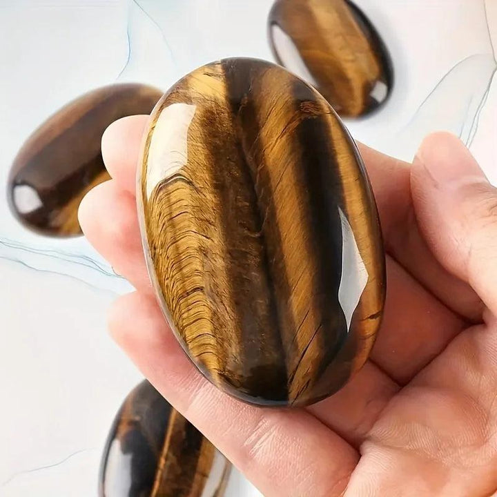 Polished tiger's eye natural crystal palm stone for stress relief and positive energy.