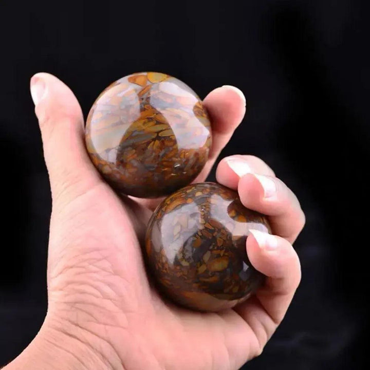 Polished Nuwa Stone Baoding Balls pair, showcasing earthy brown and amber patterns for stress relief and meditation.