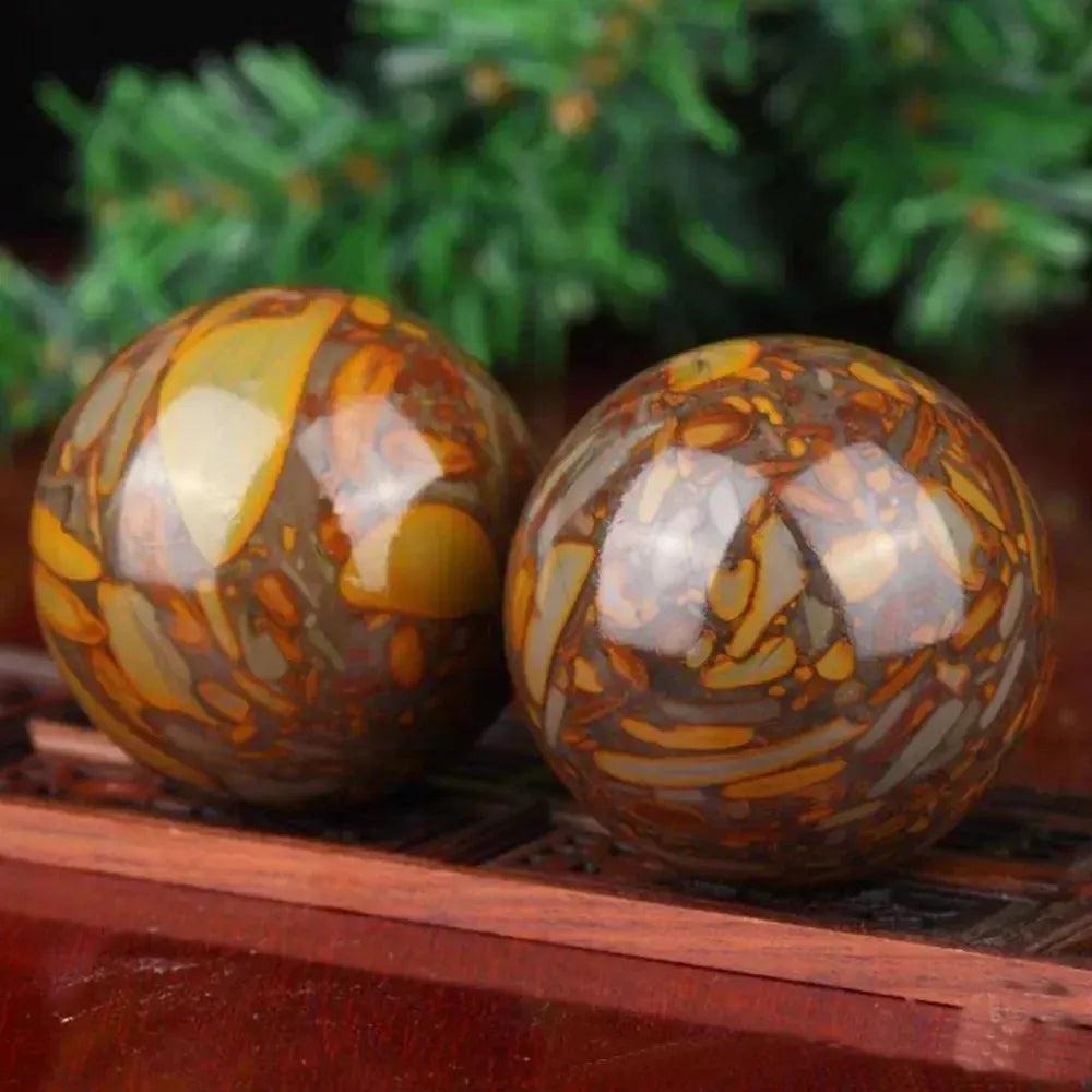 Polished Nuwa Stone Baoding Balls pair with earthy patterns, rich brown and gold tones, for stress relief and meditation.