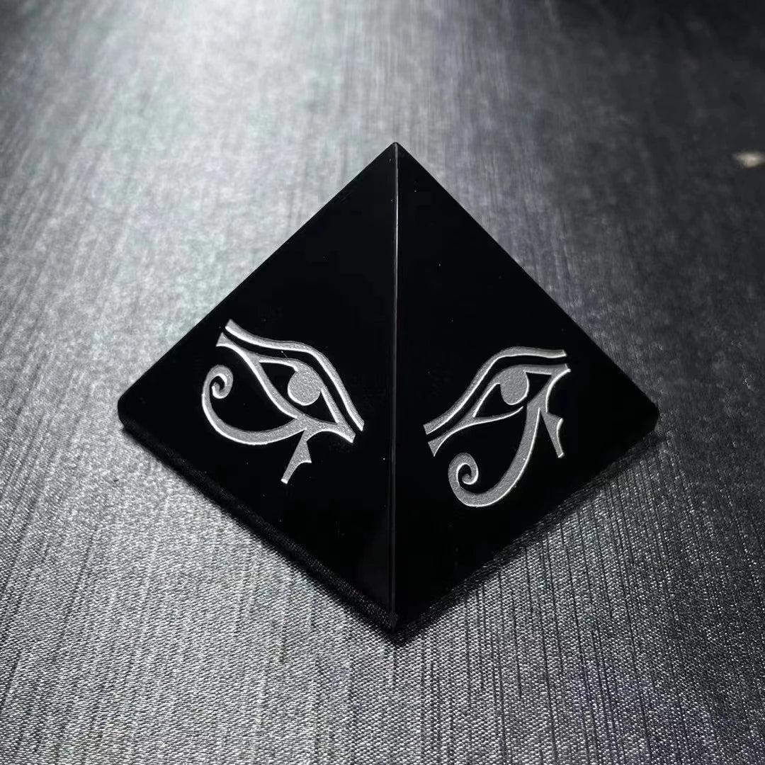 Polished black obsidian pyramid featuring a hand-engraved Eye of Horus for powerful protection and grounding energy.