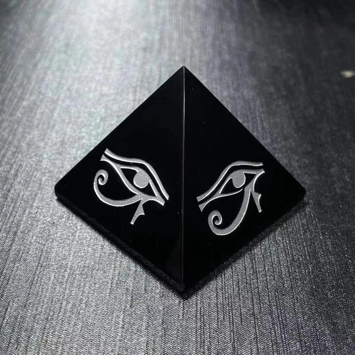 Polished black obsidian pyramid featuring a hand-engraved Eye of Horus for powerful protection and grounding energy.