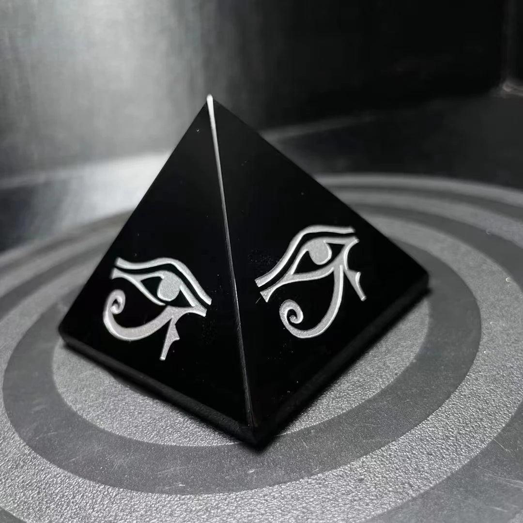 Polished black obsidian pyramid featuring hand-engraved Eye of Horus symbols for powerful energetic protection.
