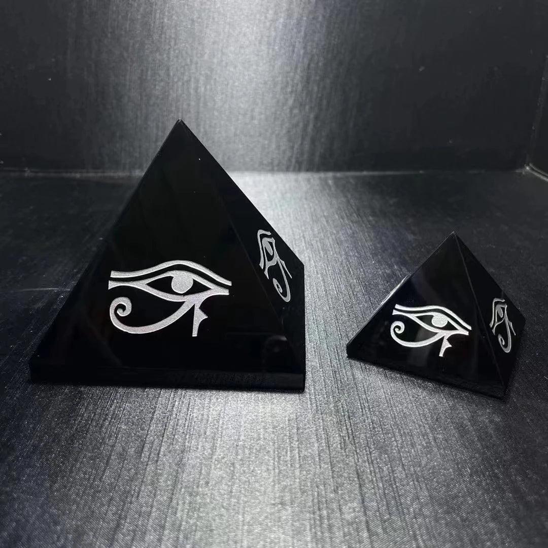 Polished black obsidian crystal pyramids featuring hand-engraved Eye of Horus symbols for grounding and protection.