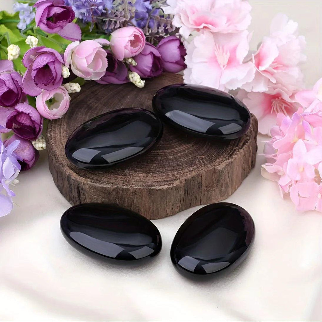Polished Obsidian Crystal Palm Stones with a glossy black finish, perfect for grounding and protection.
