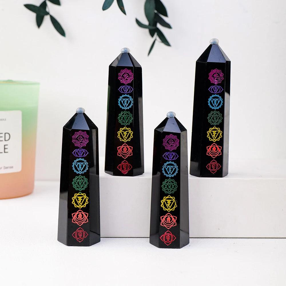 Natural black obsidian crystal towers featuring engraved colorful chakra symbols for energy healing and home decor.