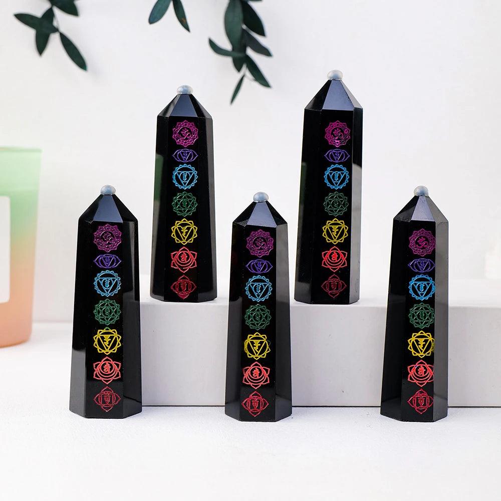 Polished black obsidian crystal towers featuring engraved, colorful chakra symbols for energy healing and home decor.