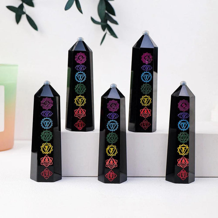 Polished black obsidian crystal towers featuring engraved, colorful chakra symbols for energy healing and home decor.