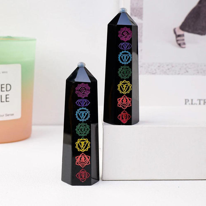 Natural black obsidian crystal towers featuring engraved colorful chakra symbols for energy healing and home decor.