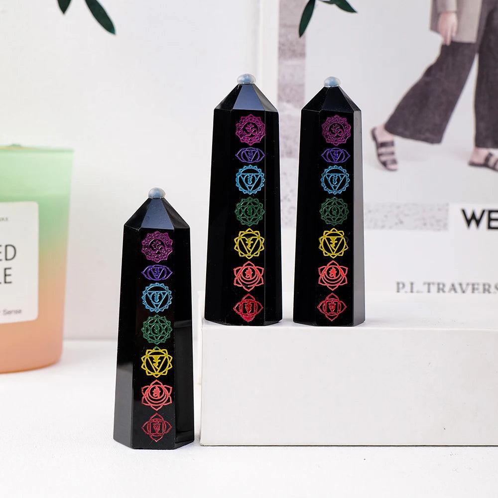 Black obsidian crystal towers featuring vibrant engraved chakra symbols for energy healing and Feng Shui home decor.