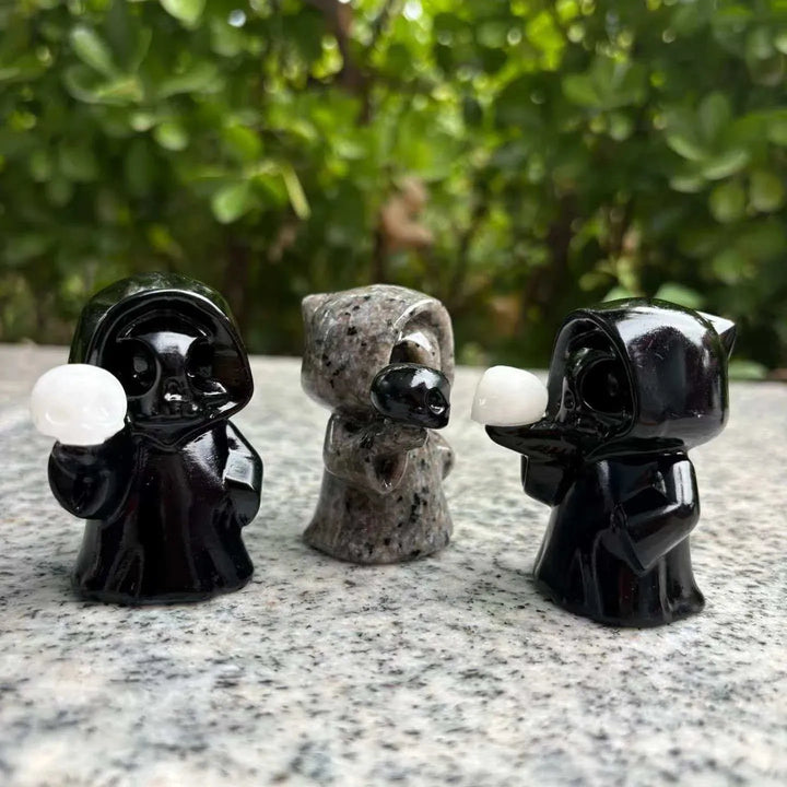 Three carved crystal ghost skull figurines in black and speckled stone, perfect for healing home decor and Halloween gifts.