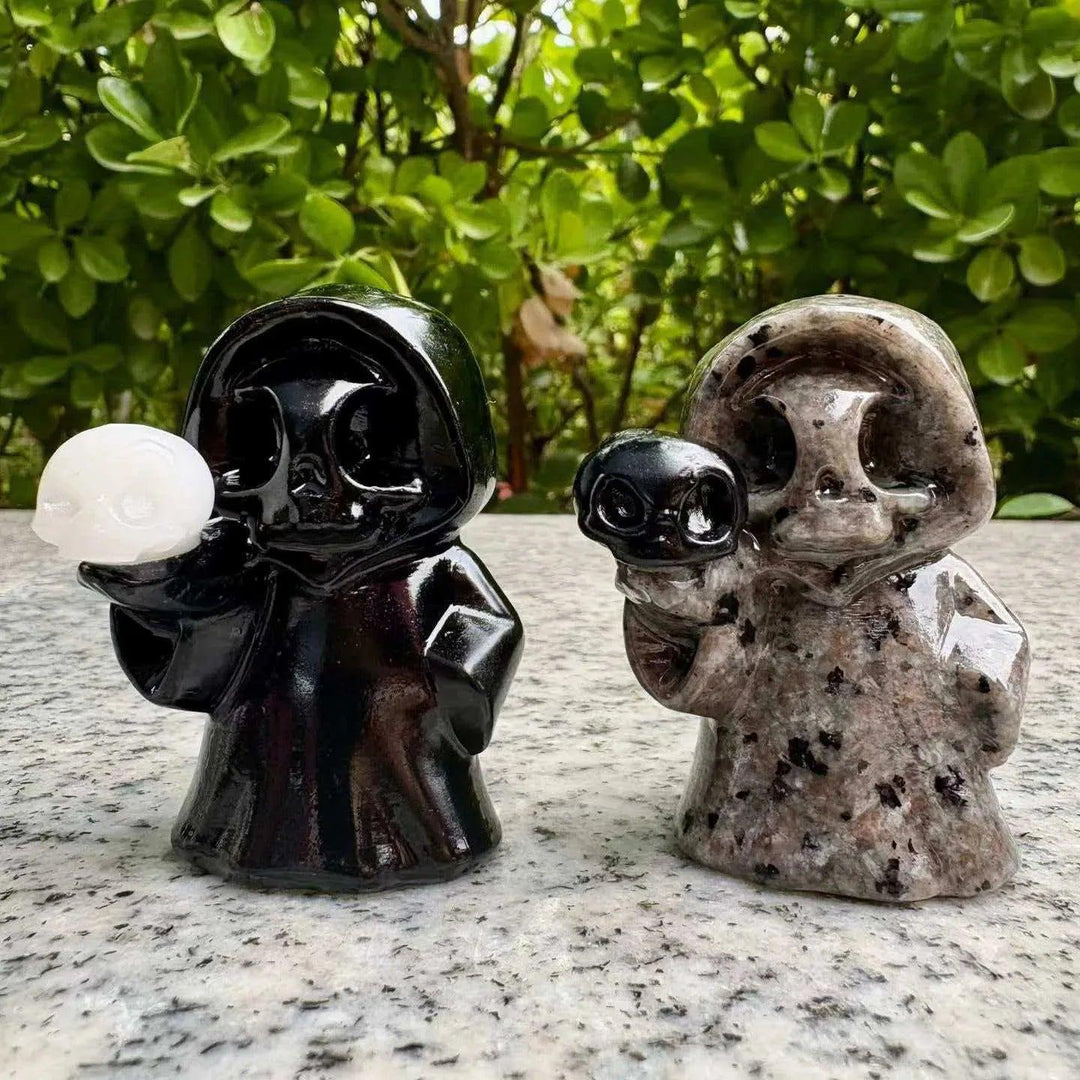Polished obsidian and granite ghost skull figurines, perfect healing crystal Halloween decor for a mystical home aesthetic.