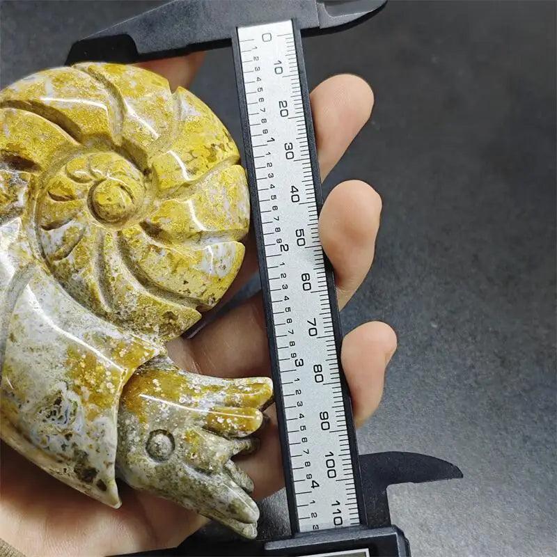 Polished Ocean Jasper snail sculpture with vibrant yellow and green orbs, measured by calipers for size and healing joy.