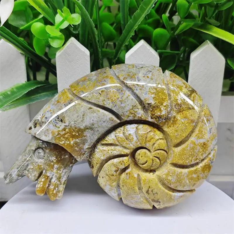 Polished Ocean Jasper snail conch sculpture featuring vibrant yellow and green orb patterns for healing and tranquility.