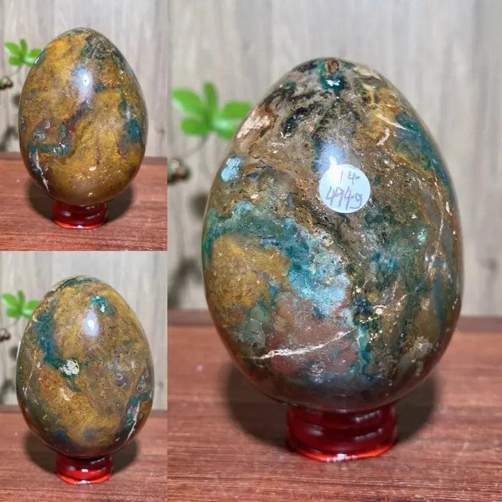 Ocean Jasper crystal egg by Crystal Destiny, featuring green, brown, and blue swirls on a red stand.