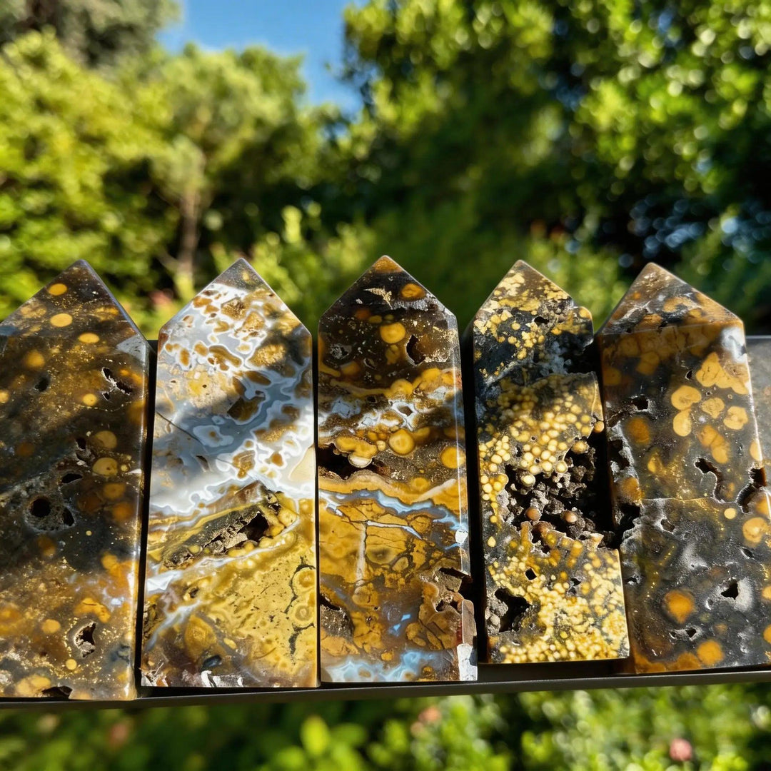 Five rare Ocean Jasper crystal obelisk towers with yellow, brown, and white orbicular patterns and druzy pockets.