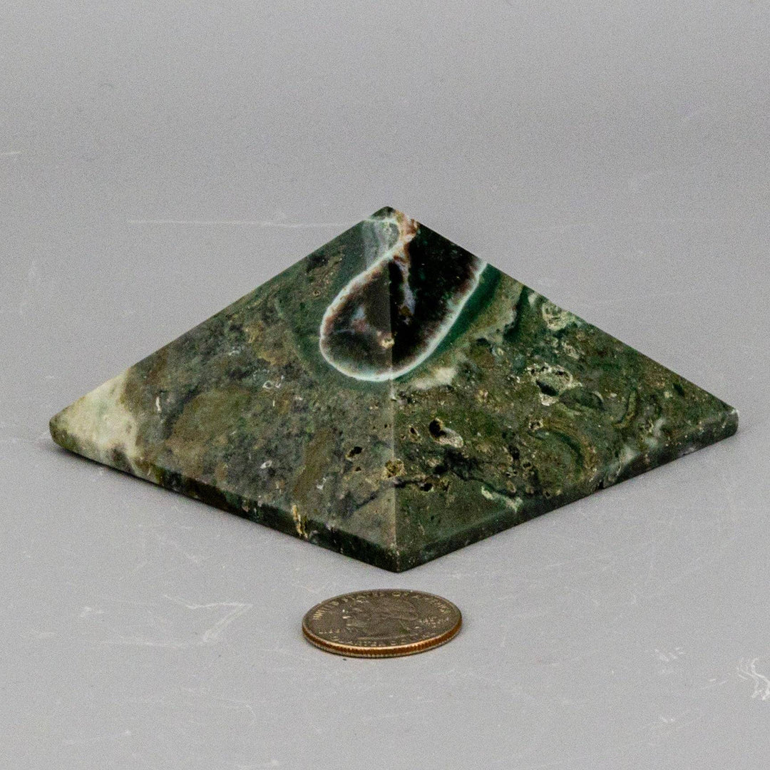Ocean Jasper Crystal Pyramid from Crystal Destiny, featuring green, cream, and earthy swirls, next to a quarter for scale.