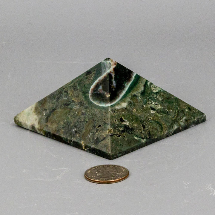 Ocean Jasper Crystal Pyramid from Crystal Destiny, featuring green, cream, and earthy swirls, next to a quarter for scale.