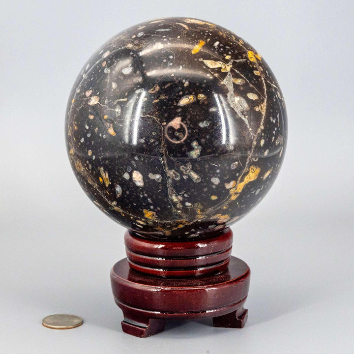 Ocean Jasper XL Sphere, 140mm, radiating warm, joyful energy. Black, green, cream, salmon, brown orbicular patterns on a stand.