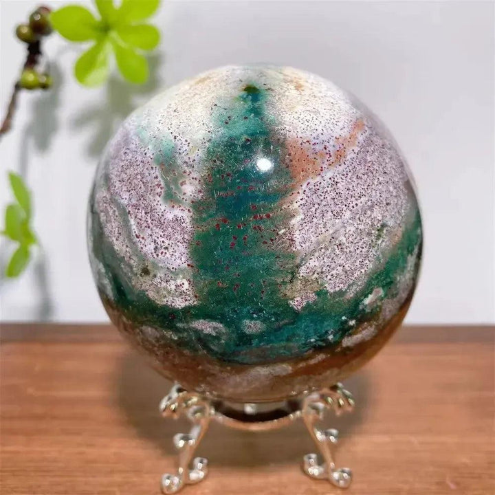 Lustrous Ocean Jasper Crystal Sphere from Crystal Destiny, featuring swirling greens, pinks, creams, and earthy tones on a silver stand.