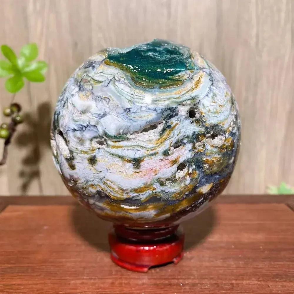 Stunning XXL Ocean Jasper Sphere with vibrant green, pink, cream, and yellow orbicular patterns on a red stand.
