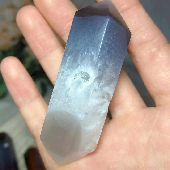 Polished Ocean Jasper double point tower in a hand, featuring soft grey and cream bands for heart chakra healing.