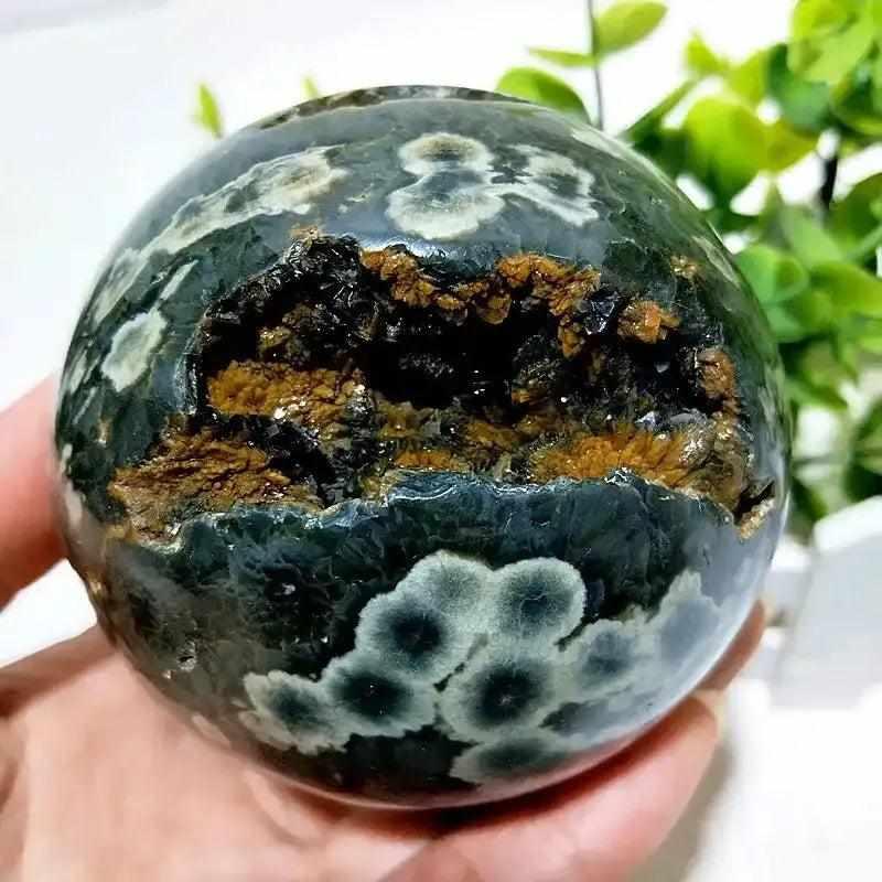 Polished Ocean Jasper geode sphere with dark orbicular patterns and a textured, sparkling druzy pocket for calm energy.