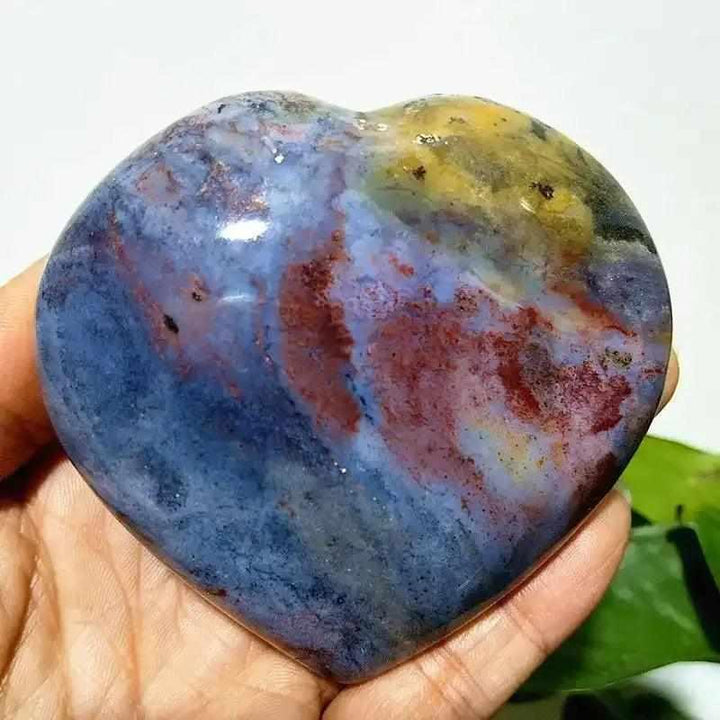 Polished Ocean Jasper heart stone featuring swirling blue, red, and yellow tones for Heart Chakra healing and tranquility.