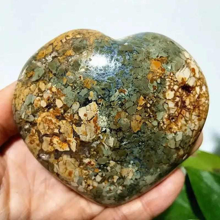 Polished Ocean Jasper heart stone featuring swirling green, white, and tan orbs for Heart Chakra healing and tranquility.