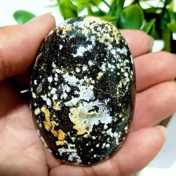 Smooth Ocean Jasper palm stone with green, cream, and pink orbs, perfect for Heart Chakra healing and calming meditation.