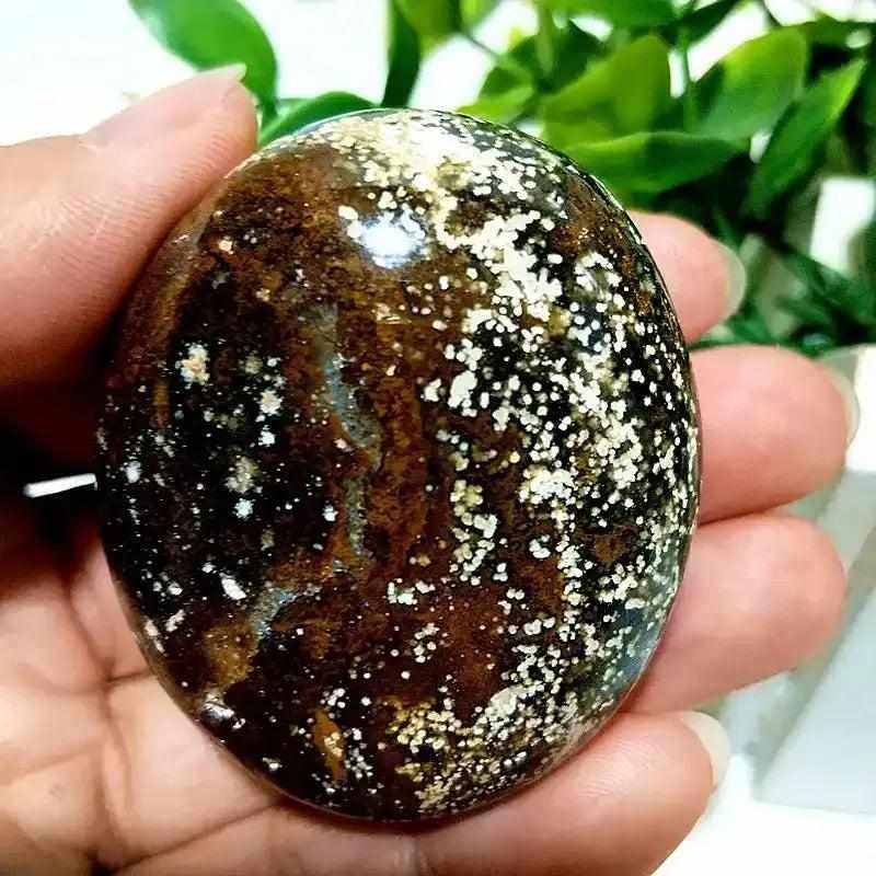 Smooth Ocean Jasper palm stone with dark brown, cream, and green orbicular patterns for Heart Chakra healing and calm.