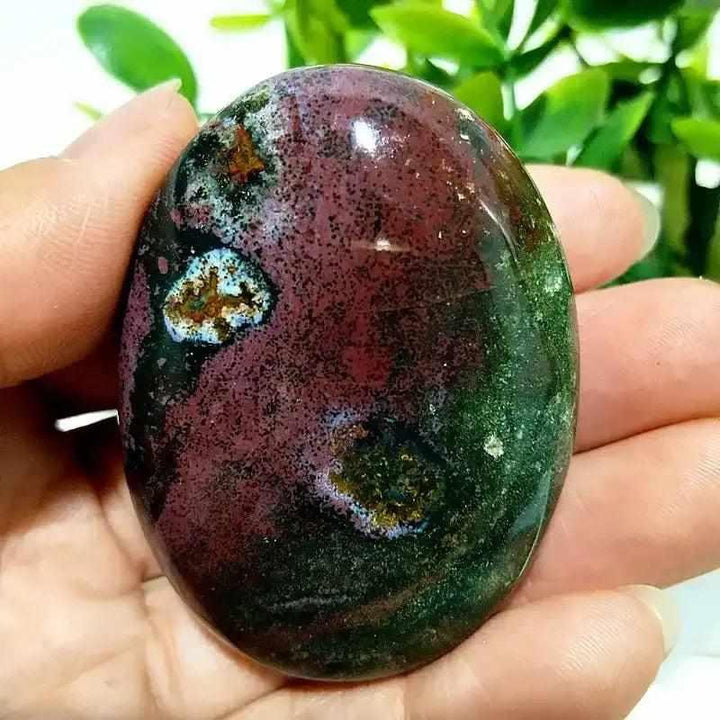 Polished Ocean Jasper palm stone with green and pink orbicular patterns, perfect for Heart Chakra healing and relaxation.