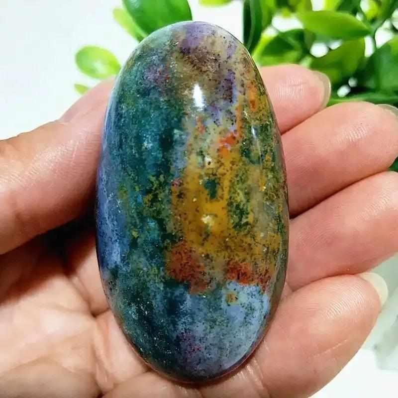Polished Ocean Jasper palm stone with green, cream, and pink swirls, perfect for heart chakra healing and meditation.