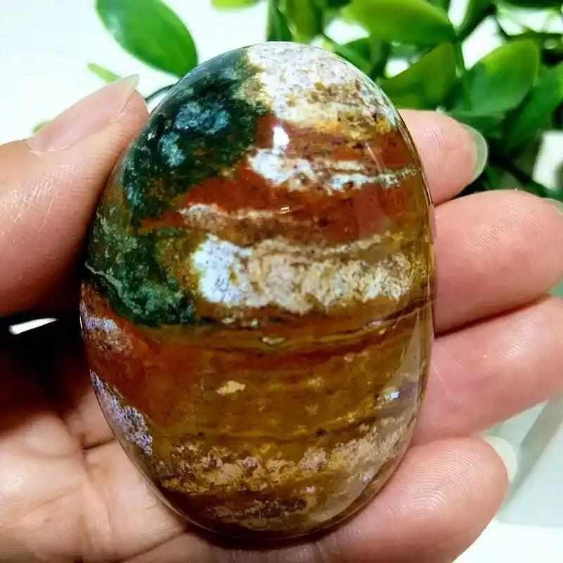 Polished Ocean Jasper palm stone with green, cream, and pink swirls, perfect for Heart Chakra healing and stress relief.