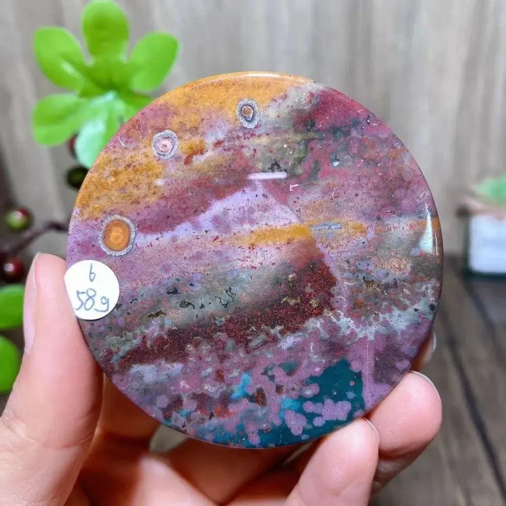 Polished Ocean Jasper round slice from Crystal Destiny, featuring vibrant pink, green, orange, and purple orb patterns.