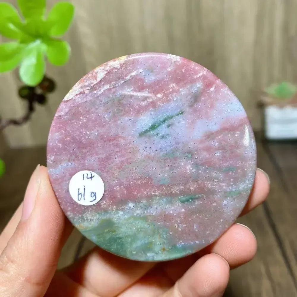 Crystal Destiny Ocean Jasper round slice, featuring pink, green, and white swirling patterns.