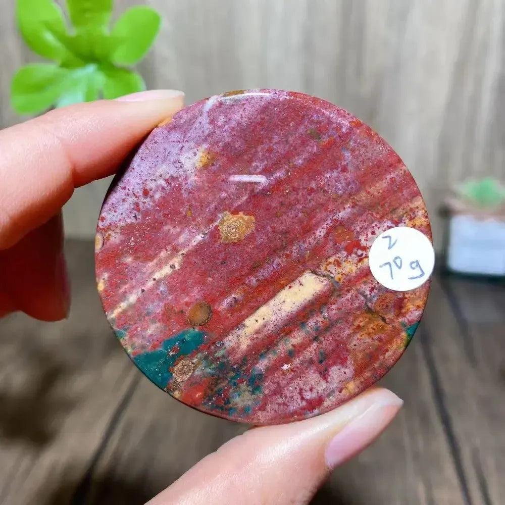 Crystal Destiny Ocean Jasper round slice, 70g, with red, green, yellow, and white patterns.