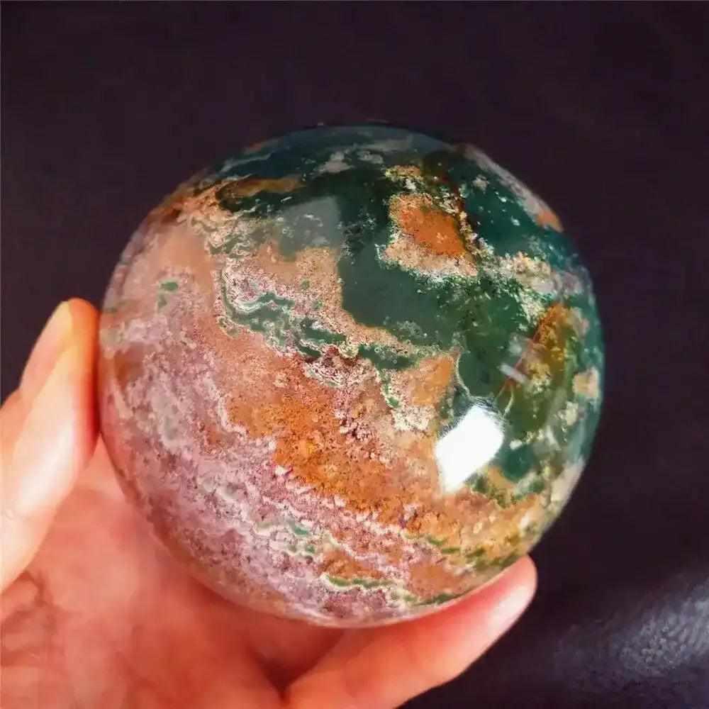 Polished Ocean Jasper sphere featuring swirling sea green, cream, and pink orb patterns for heart chakra healing.