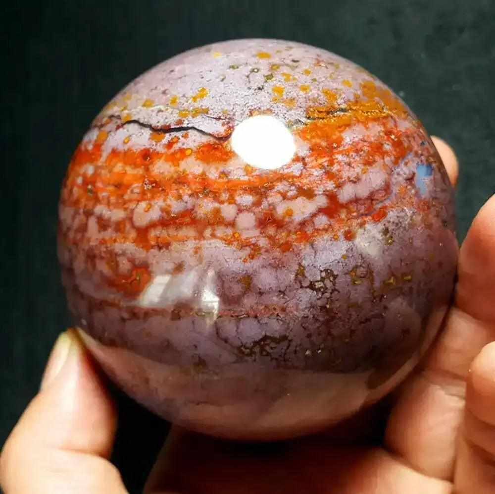 Polished Ocean Jasper sphere featuring swirling pink, cream, and green orb patterns for heart and throat chakra healing.