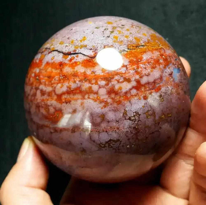 Polished Ocean Jasper sphere featuring swirling pink, cream, and green orb patterns for heart and throat chakra healing.