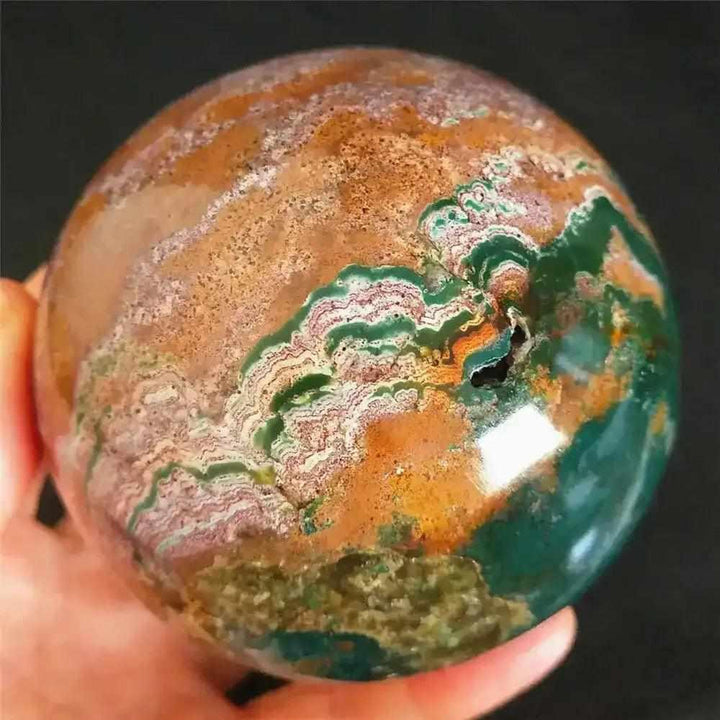 Polished Ocean Jasper sphere featuring flowing sea green, cream, and pink bands for heart chakra healing and tranquility.