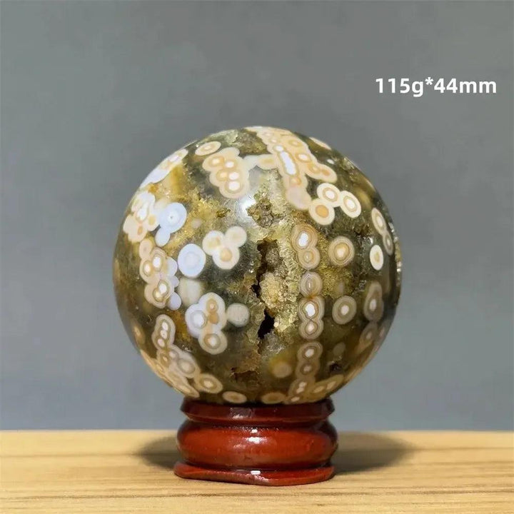 Ocean Jasper sphere from Crystal Destiny, 115g, 44mm, with green, white, cream orbicular patterns on a red base.