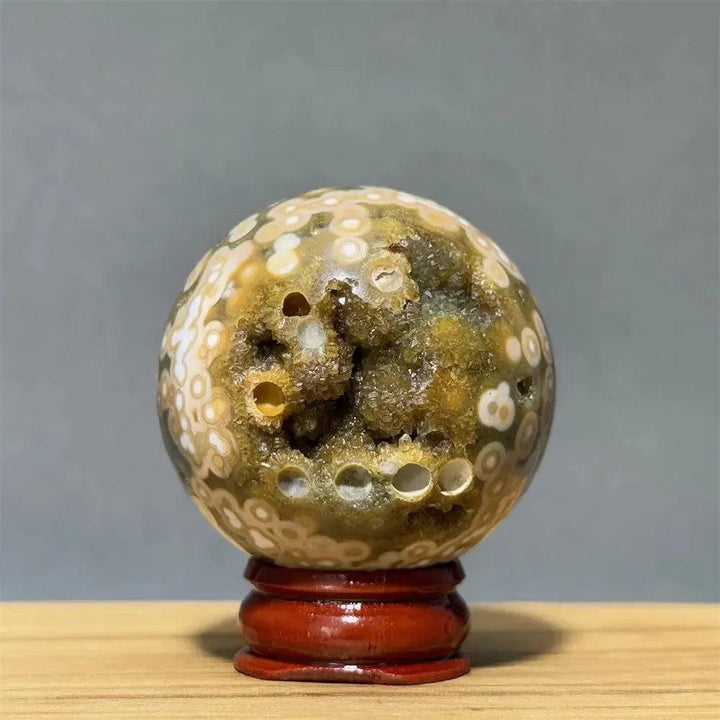 Ocean Jasper sphere from Crystal Destiny, with green, white, cream, pink orbicular patterns and a geode cavity.
