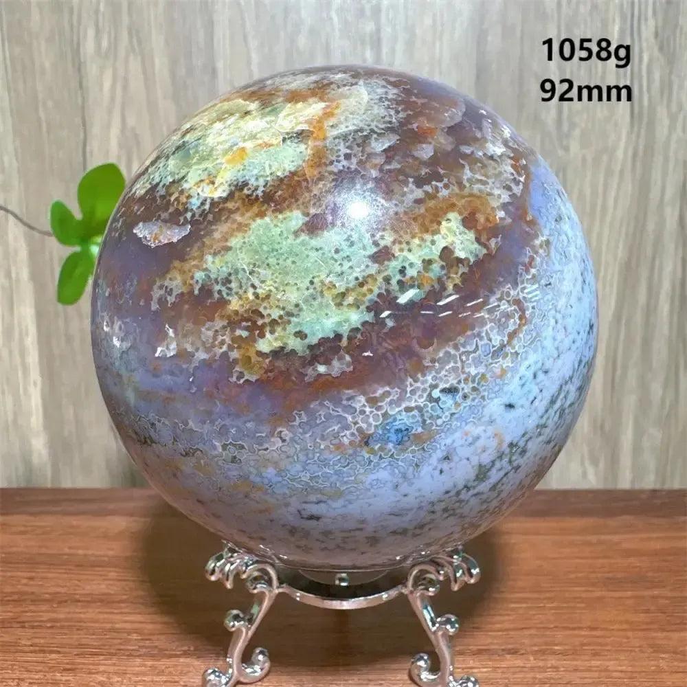 Ocean Jasper sphere from Crystal Destiny, 92mm, 1058g, with swirling greens, purples, and blues on a silver stand.