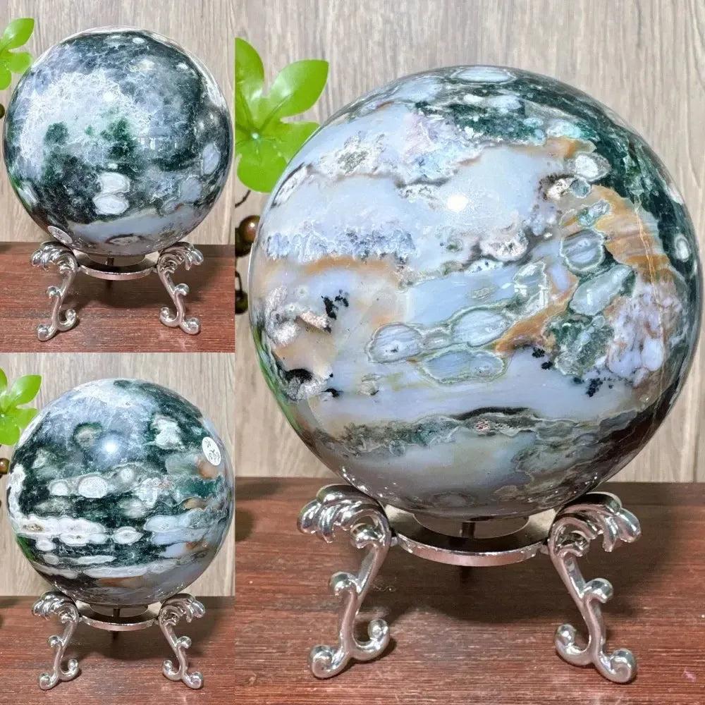 Ocean Jasper sphere from Crystal Destiny, featuring swirling greens, whites, and browns on a silver stand.