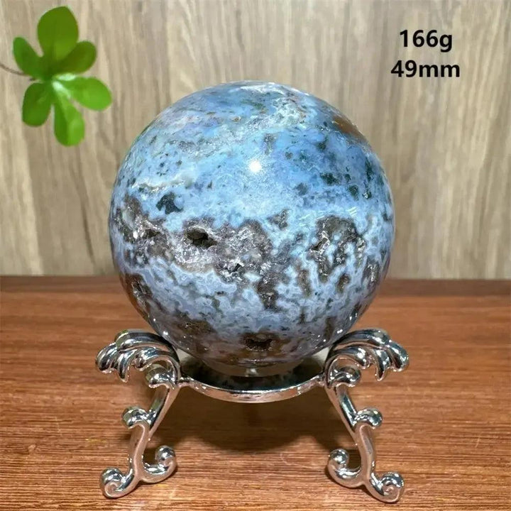 Crystal Destiny's blue and brown Ocean Jasper sphere (166g, 49mm) on a silver stand, promoting tranquility.