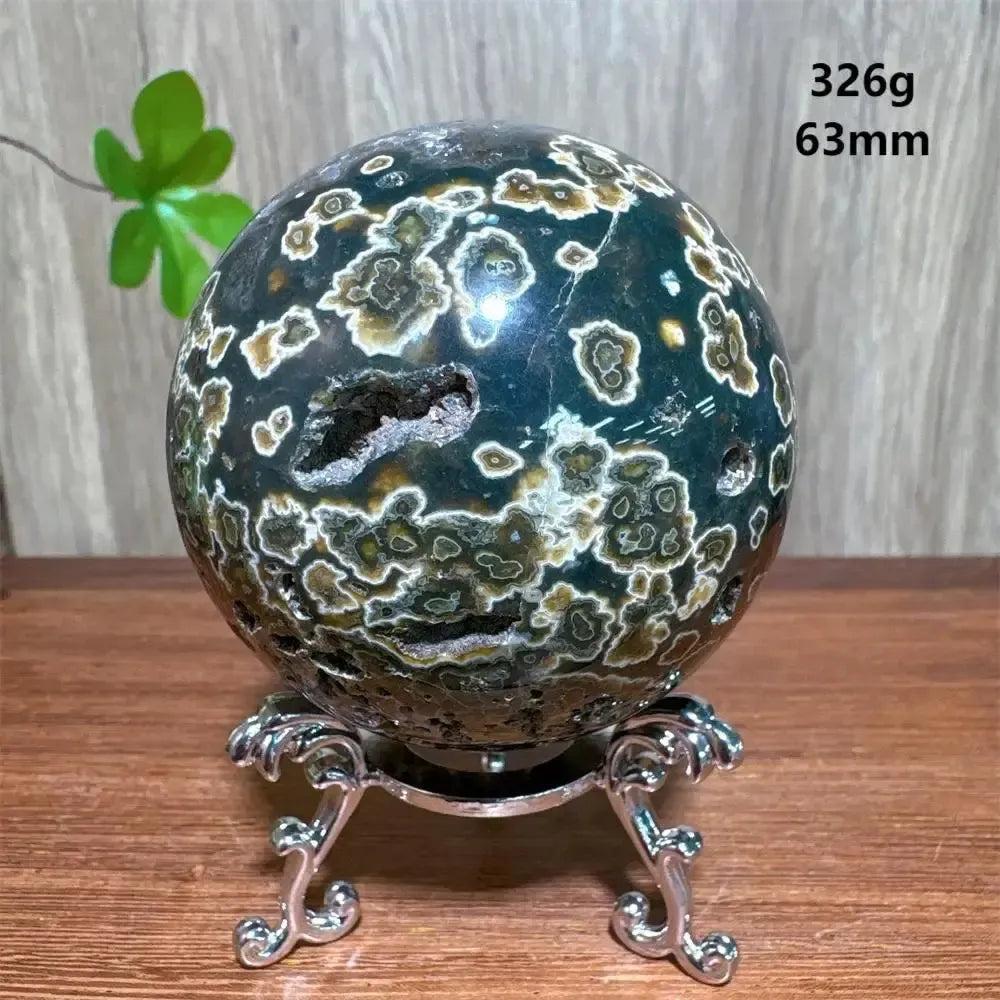 Crystal Destiny's 63mm Ocean Jasper sphere, dark green with white orbicular patterns, on a silver stand.