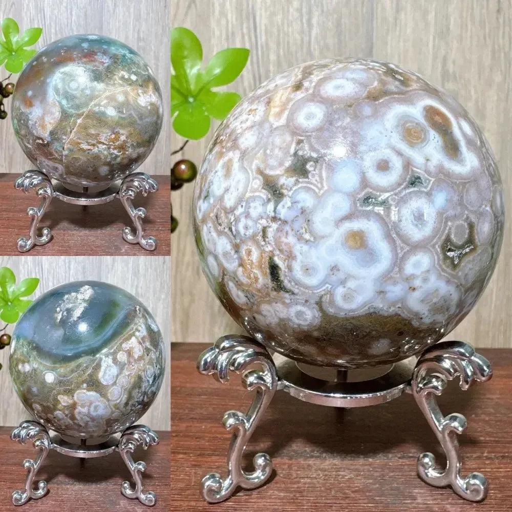 Ocean Jasper sphere from Crystal Destiny, featuring unique orbicular patterns in greens, whites, pinks, and browns on a stand.