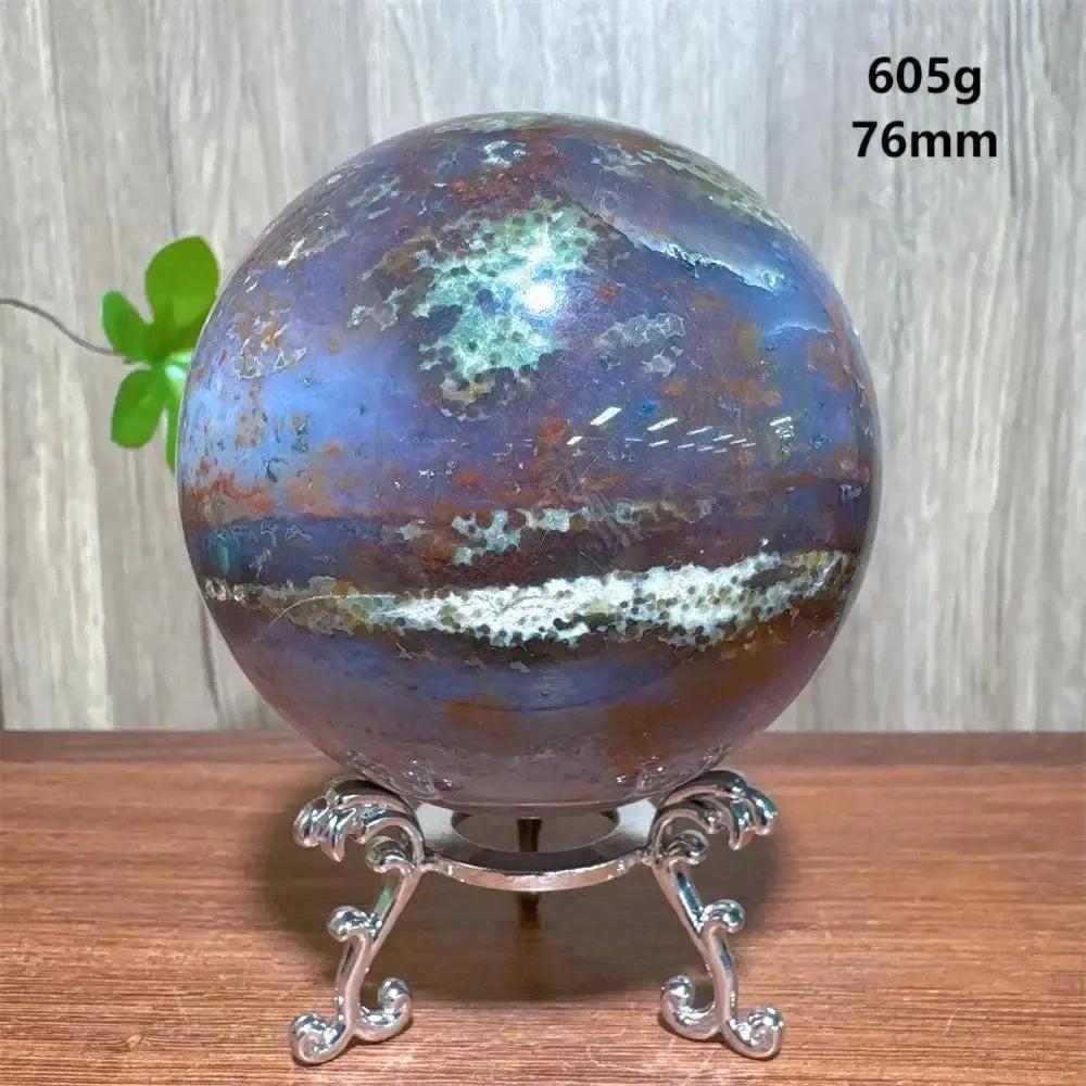 Crystal Destiny's Ocean Jasper sphere, 76mm, 605g, with unique blue, green, and white orbicular patterns on a silver stand.